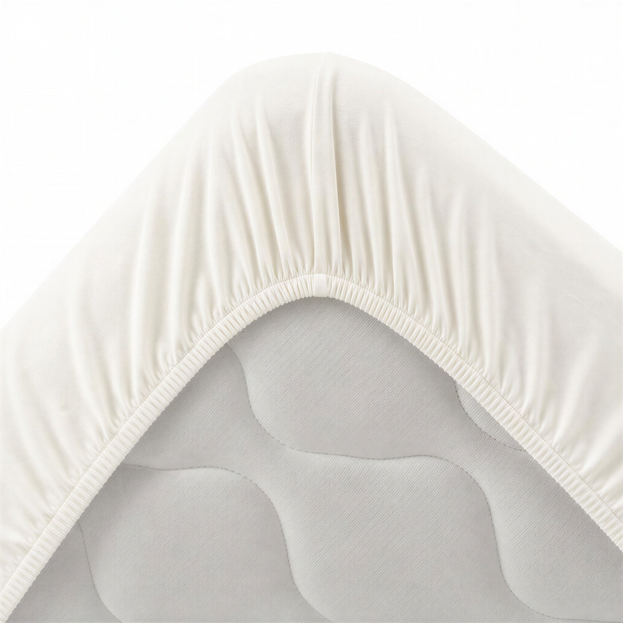 Bettecke mit umlaufendem Gummizug – perlmuttfarbenes Spannbettlaken im Detail